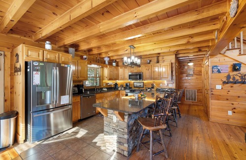 Ellijay Cabin | Ideal for large families, this riverfront gem boasts a dock, firepit, hot tub, basketball court, and a pool table for endless fun. Pet Friendly and WiFi