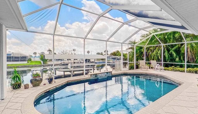 Dog-friendly waterfront home with heated pool, lanai, central AC, & W/D