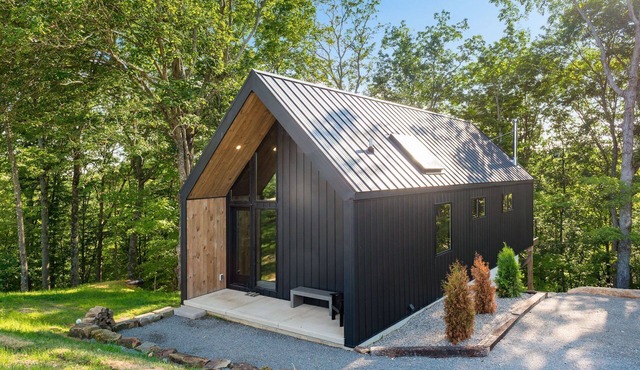 Luxury Couples Cabin in Hocking Hills, Ohio with private hot tub and outdoor fireplace on covered private balcony with forest views.